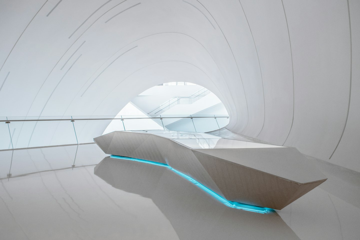 Meja resepsionis modern dengan lampu biru di gedung putih.